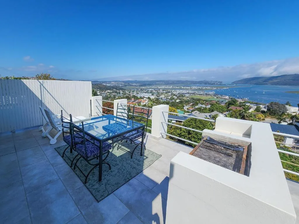 Elevated deck with dining table, braai, and sweeping lagoon views