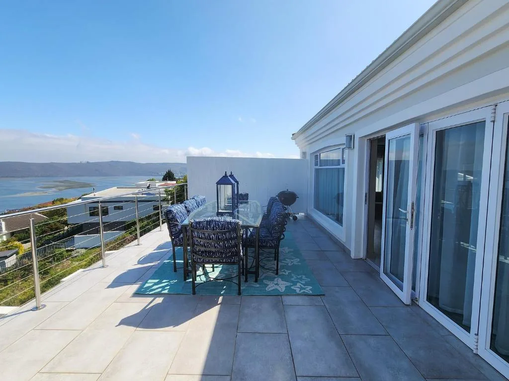 Spacious terrace with dining table overlooking lagoon and mountains