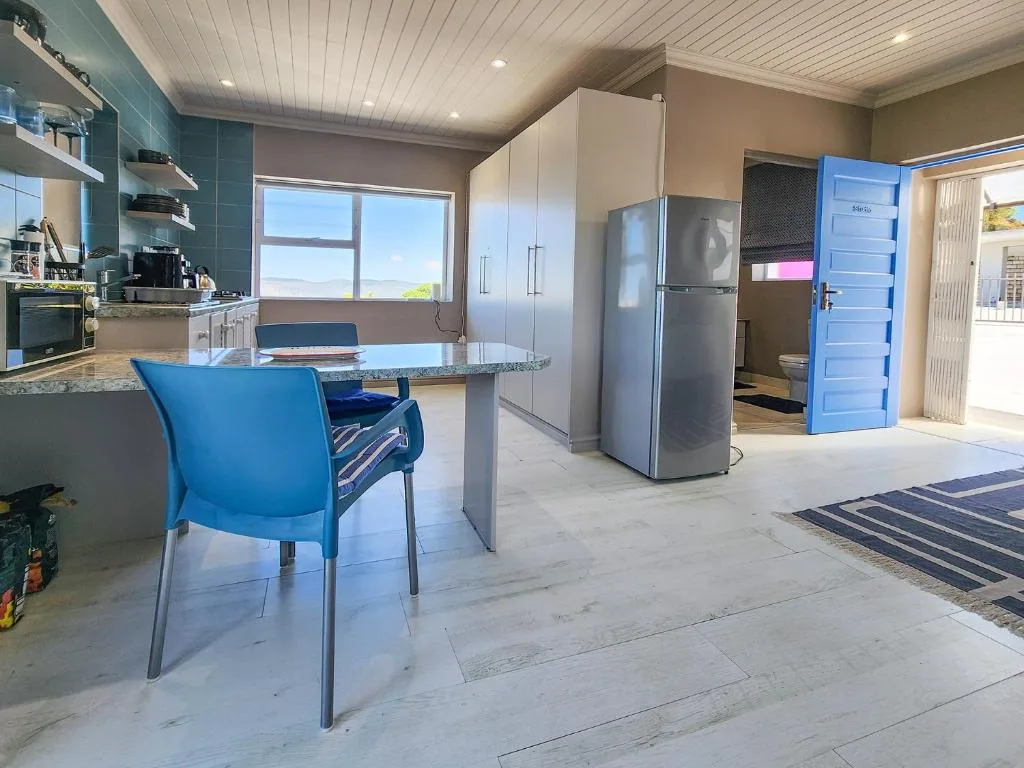 Modern kitchen with stainless steel appliances, white cabinetry, and dining counter