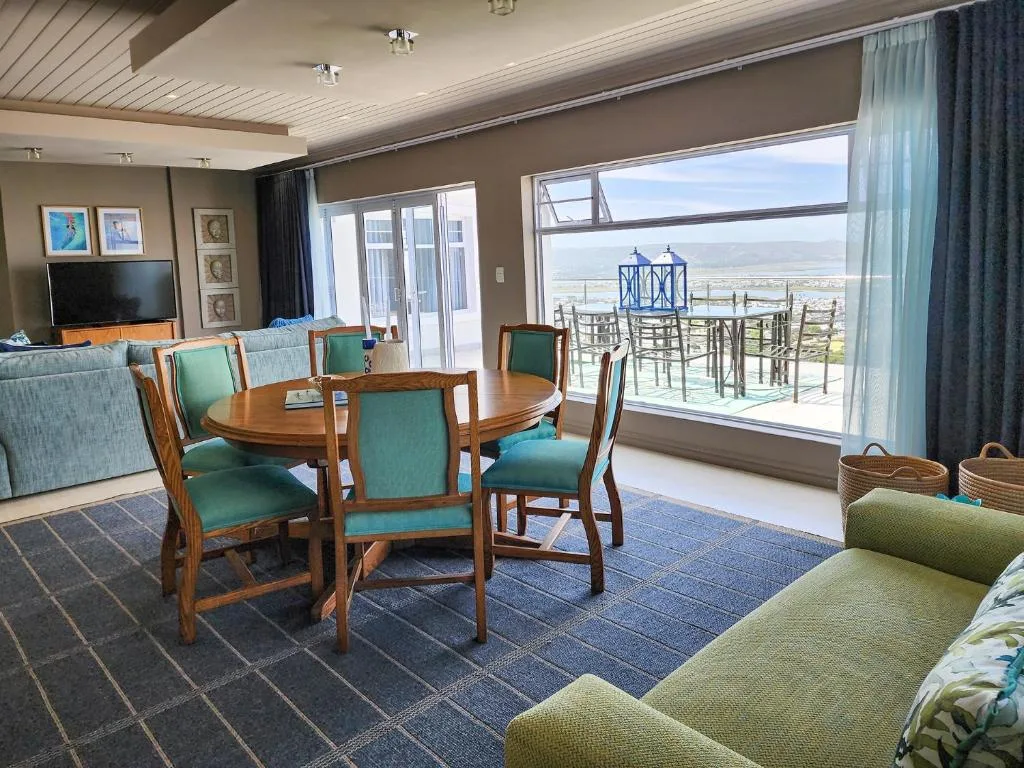Open-plan lounge and dining area with expansive deck views over Knysna lagoon