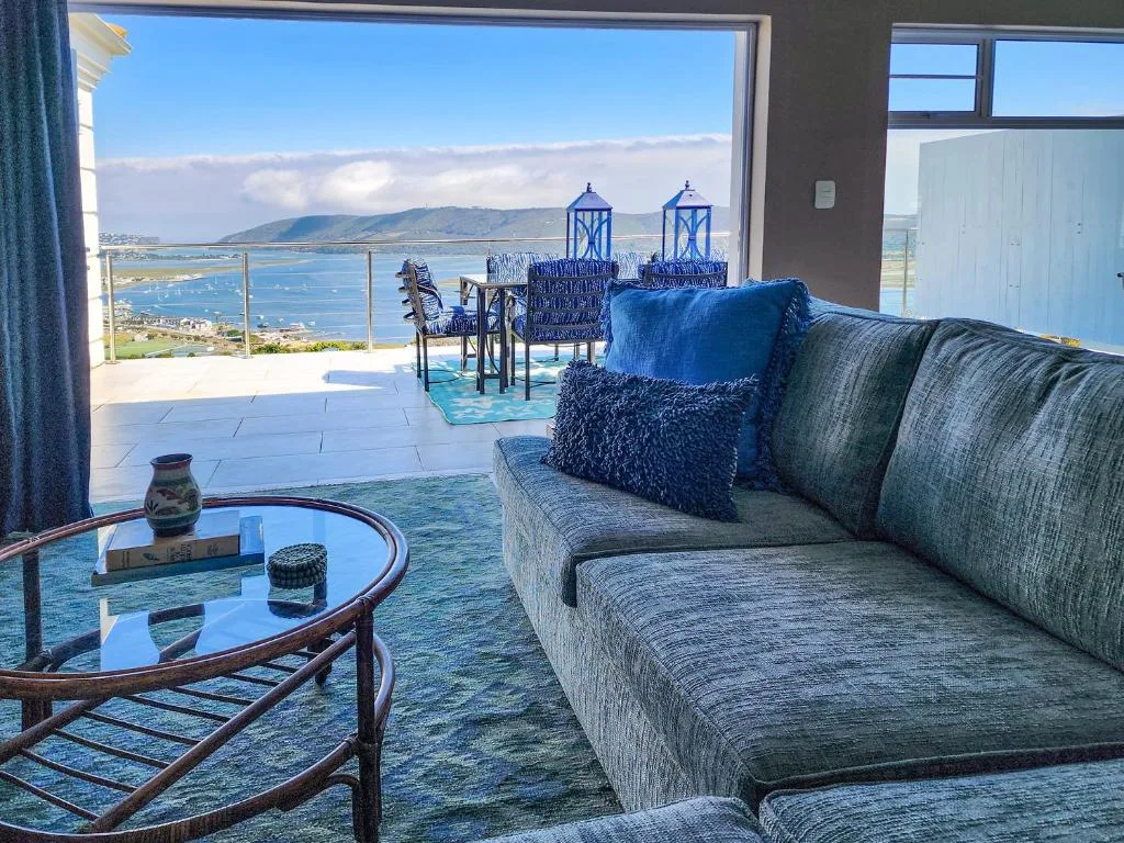 Modern lounge with sofa overlooking Knysna lagoon and mountains from large windows