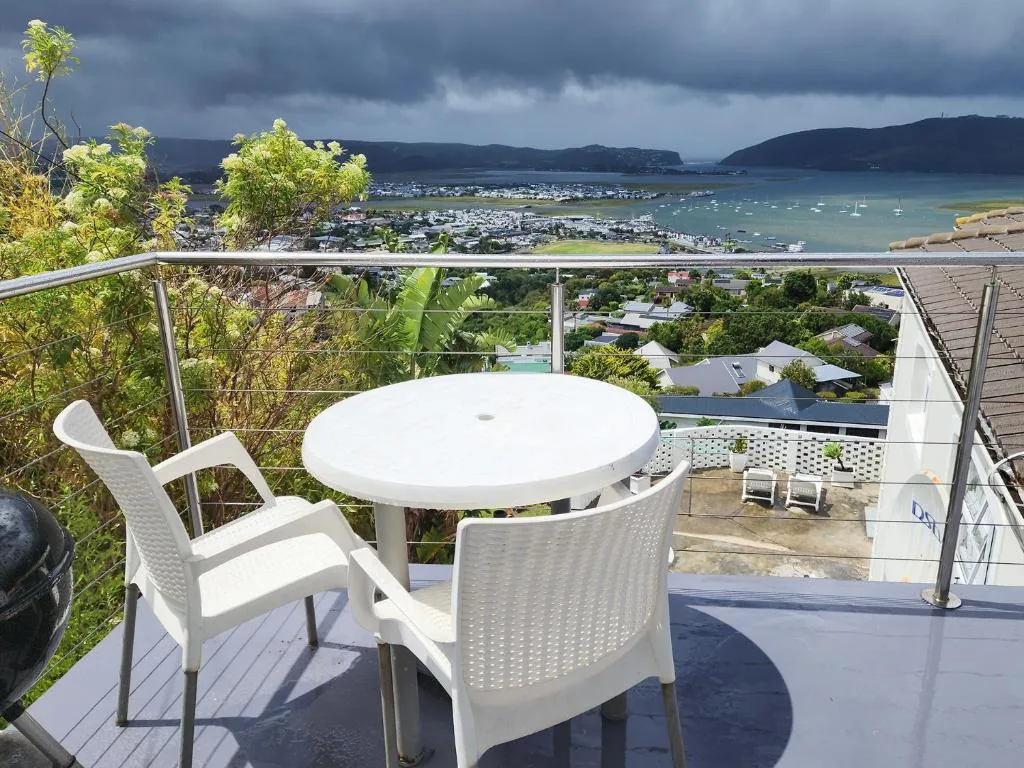 Expansive coastal bay view with sailboats from elevated deck seating area
