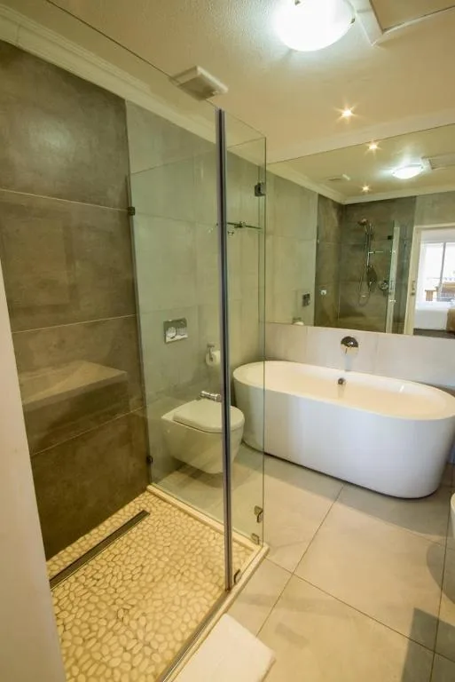 Modern bathroom with walk-in shower, freestanding bathtub, and neutral tile finishes