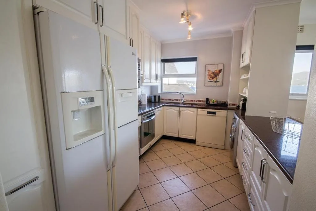 Modern kitchen with white cabinetry, stainless steel appliances, and tiled flooring