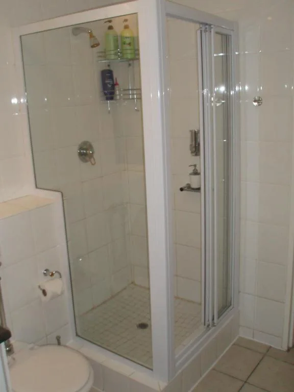 Modern bathroom with glass shower enclosure and white tile walls