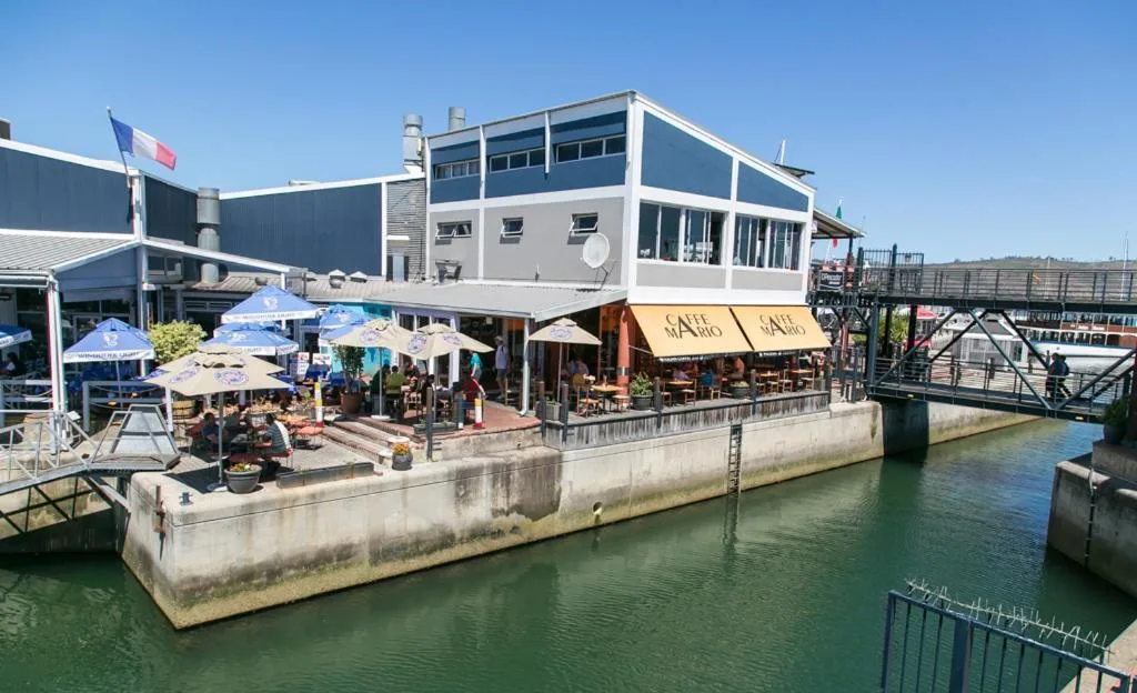 Waterfront apartment building with outdoor dining deck and harbor views