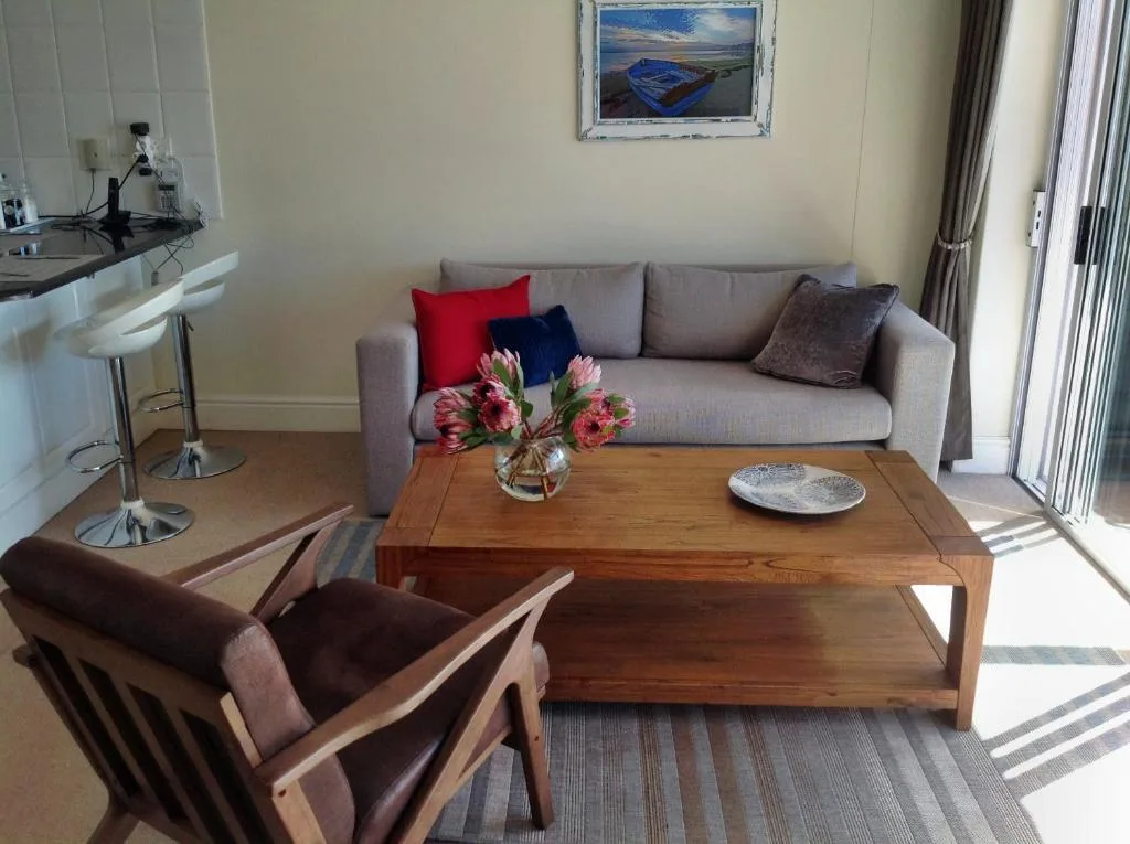 Modern lounge with gray sofa, wooden coffee table, and decorative flowers