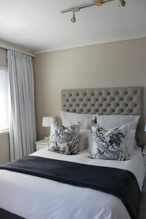 Modern bedroom with upholstered grey headboard and decorative pillows