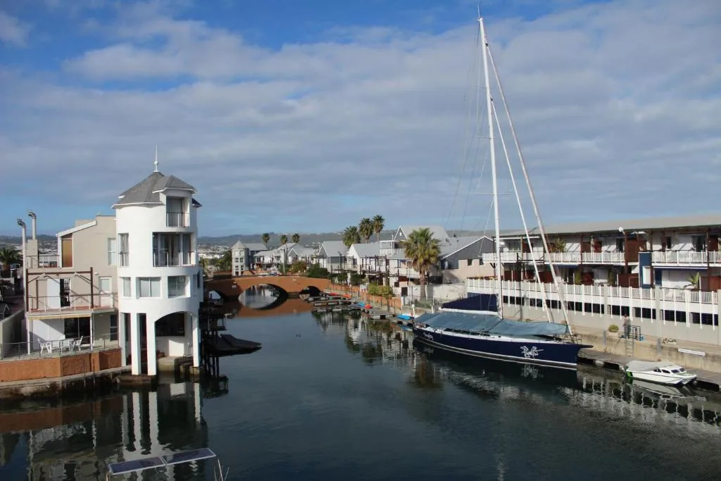 Scenic waterfront view of Knysna with sailboat and waterfront buildings