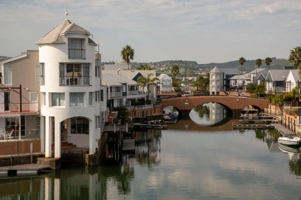 Waterfront apartment with lagoon, bridge, and palm trees in background