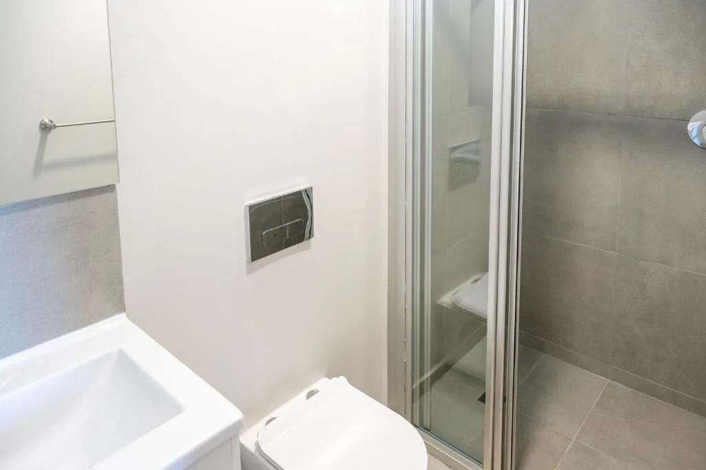 Modern bathroom with toilet, shower enclosure, and tiled walls