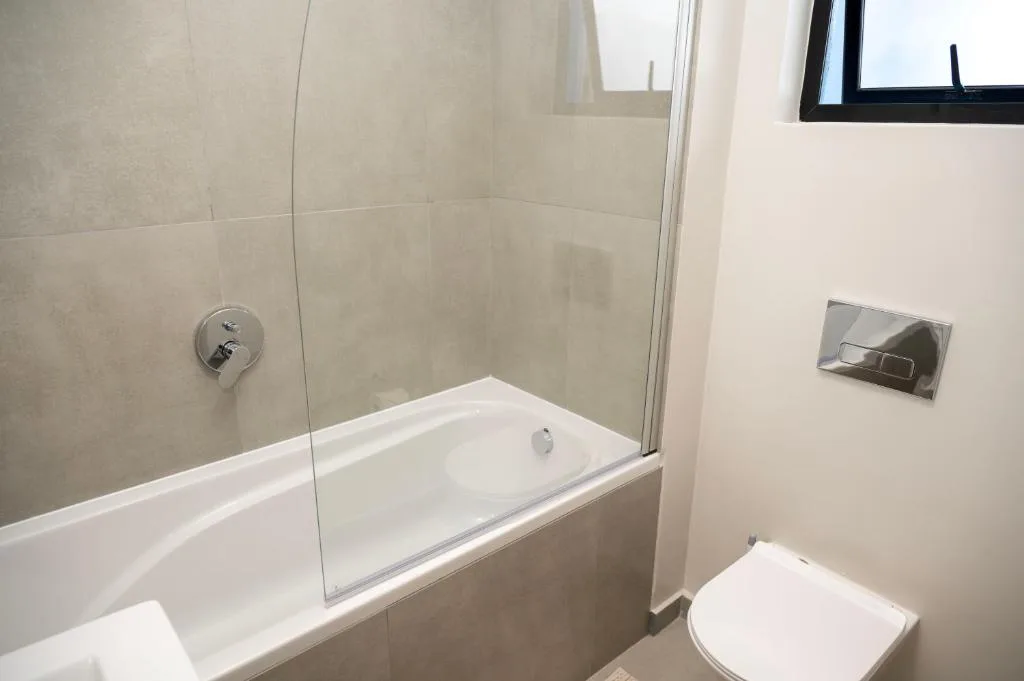 Modern bathroom with bathtub, glass shower enclosure, and toilet