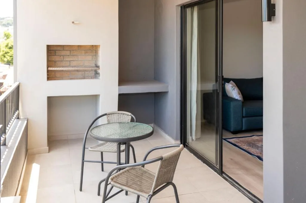 Small outdoor patio with table, chairs, and braai area access