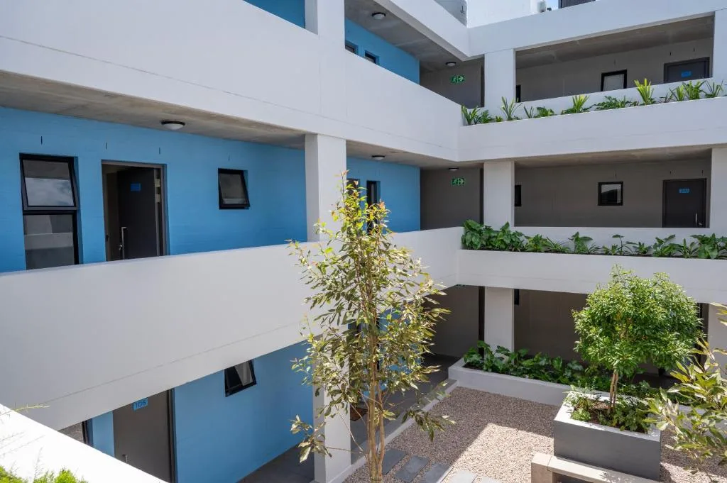Modern blue and white apartment building with planted courtyards and balconies