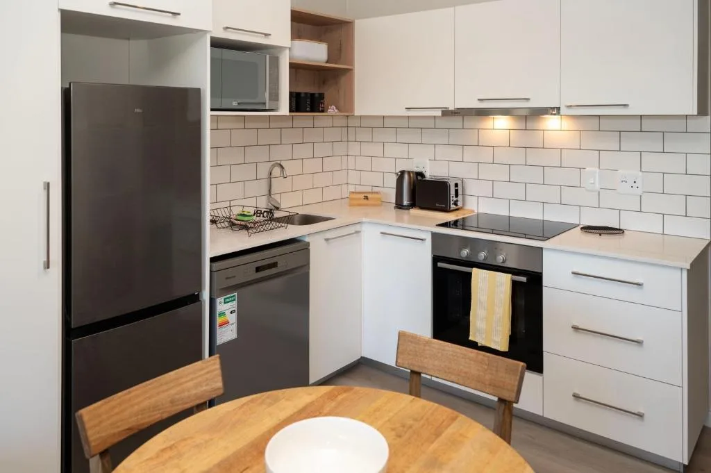 Modern kitchen with white cabinetry, stainless steel appliances, and subway tile backsplash