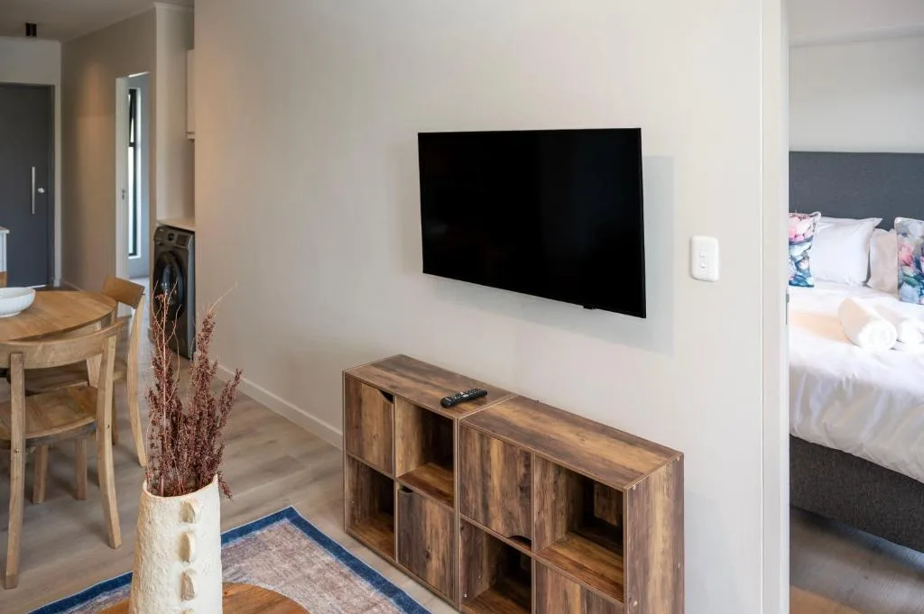 Modern lounge with wall-mounted TV and wooden storage unit