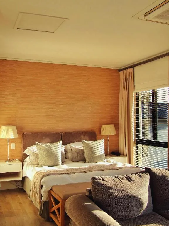Warm bedroom with brown leather headboard and cream bedding and pillows