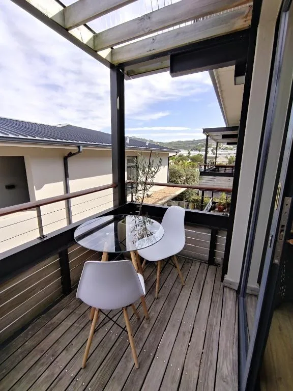 Modern covered deck with table, chairs, and scenic mountain views beyond
