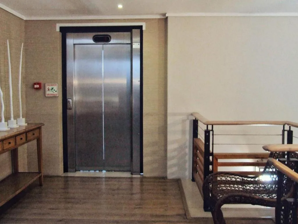 Modern elevator entrance in apartment hallway with wooden console table