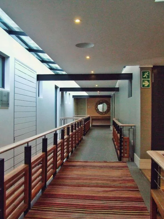 Modern hallway with wooden railings and recessed ceiling lights