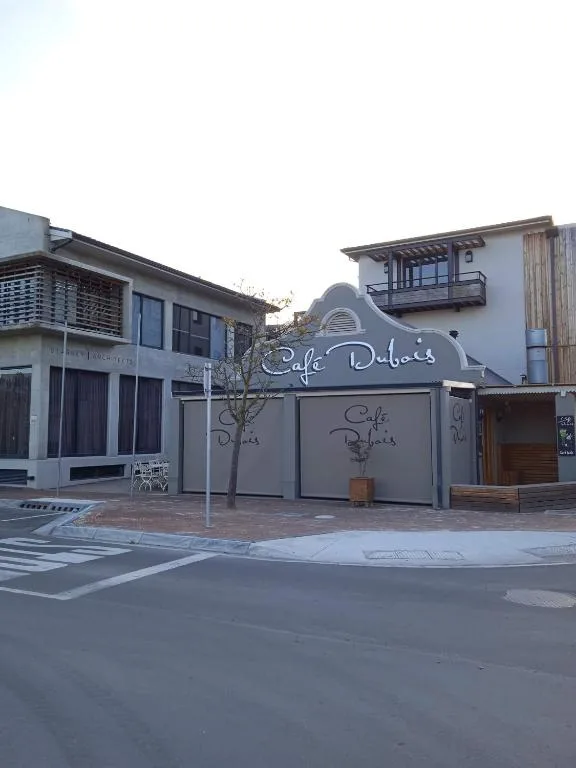 Modern building facade with gray shutters and curved signage entrance
