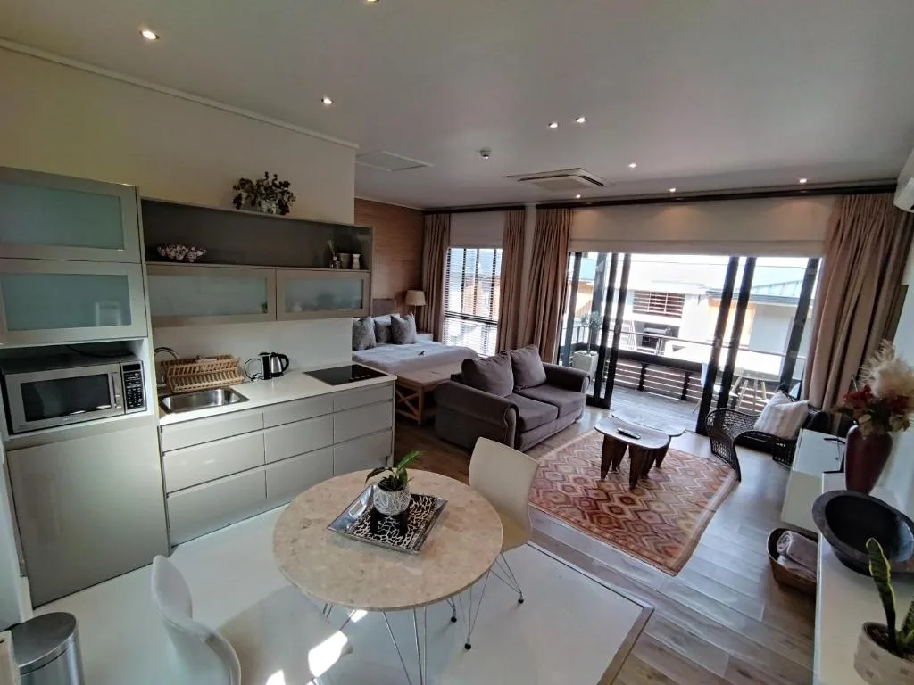 Open-plan living area with lounge seating, kitchen, and ocean view deck access