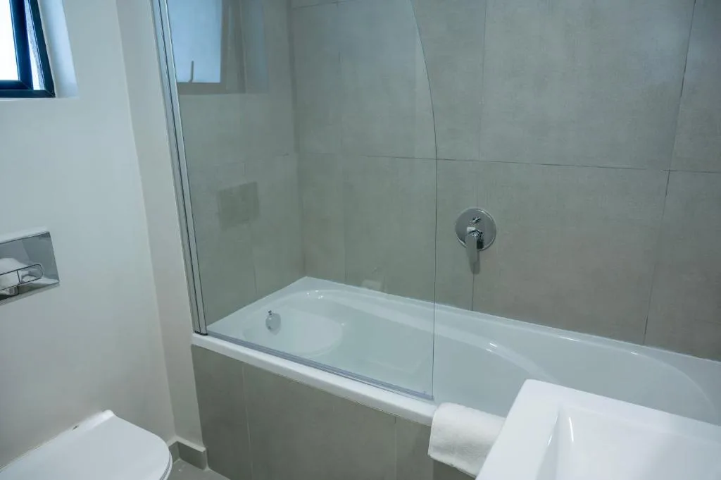Modern bathroom with bathtub, glass shower enclosure, and tiled walls