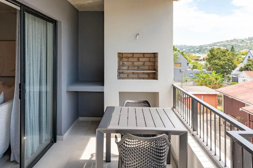 Outdoor balcony with dining table overlooking hillside neighborhood views
