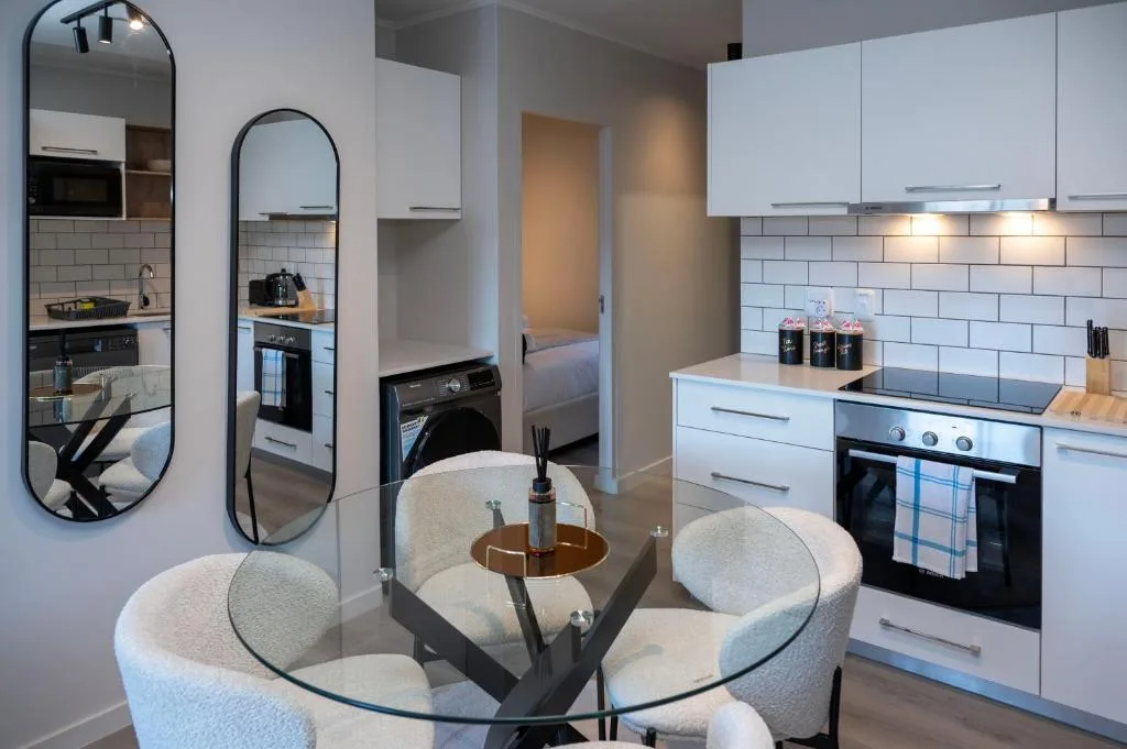 Modern white kitchen with subway tile backsplash, built-in appliances, and dining area