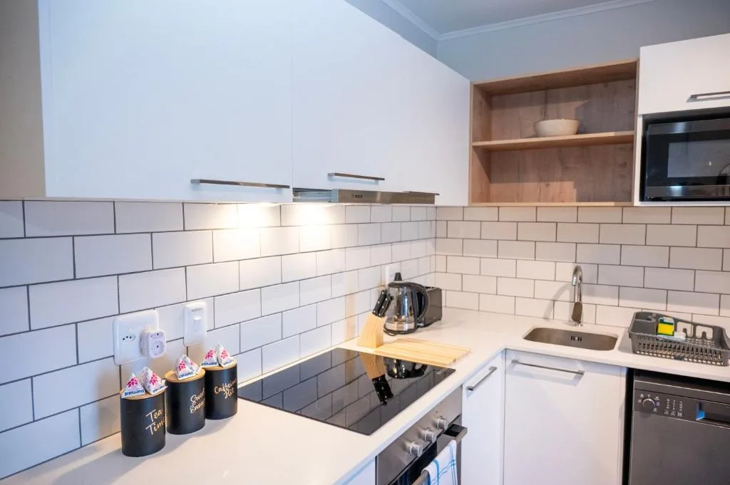 Modern kitchen with white cabinetry, subway tile backsplash, and stainless steel appliances