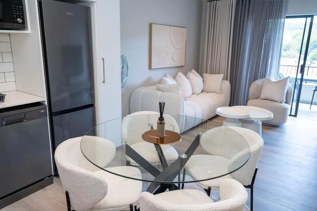 Modern open-plan lounge with cream sofa, dining table, and kitchen area