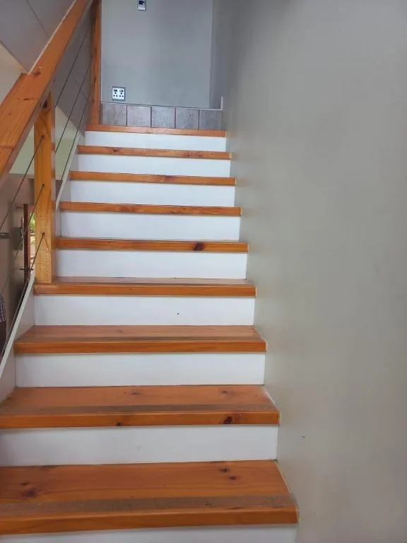 Modern wooden and white staircase with natural timber treads and railing