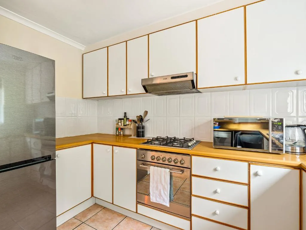 Modern kitchen with white cabinetry, wooden countertops, gas stove