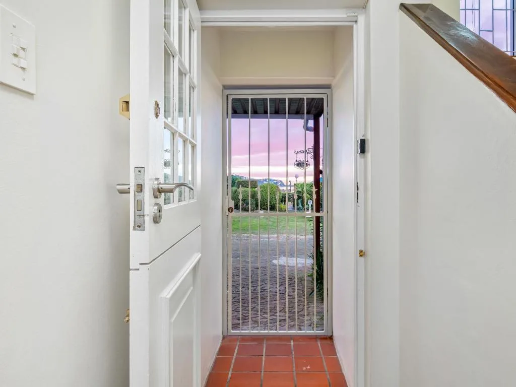 Garden and landscape vista through open glass door at sunset