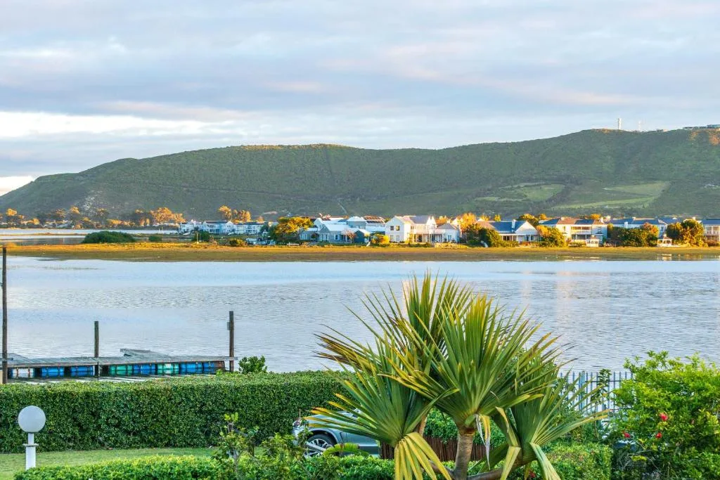 Scenic lagoon view with colorful waterfront homes and green mountains