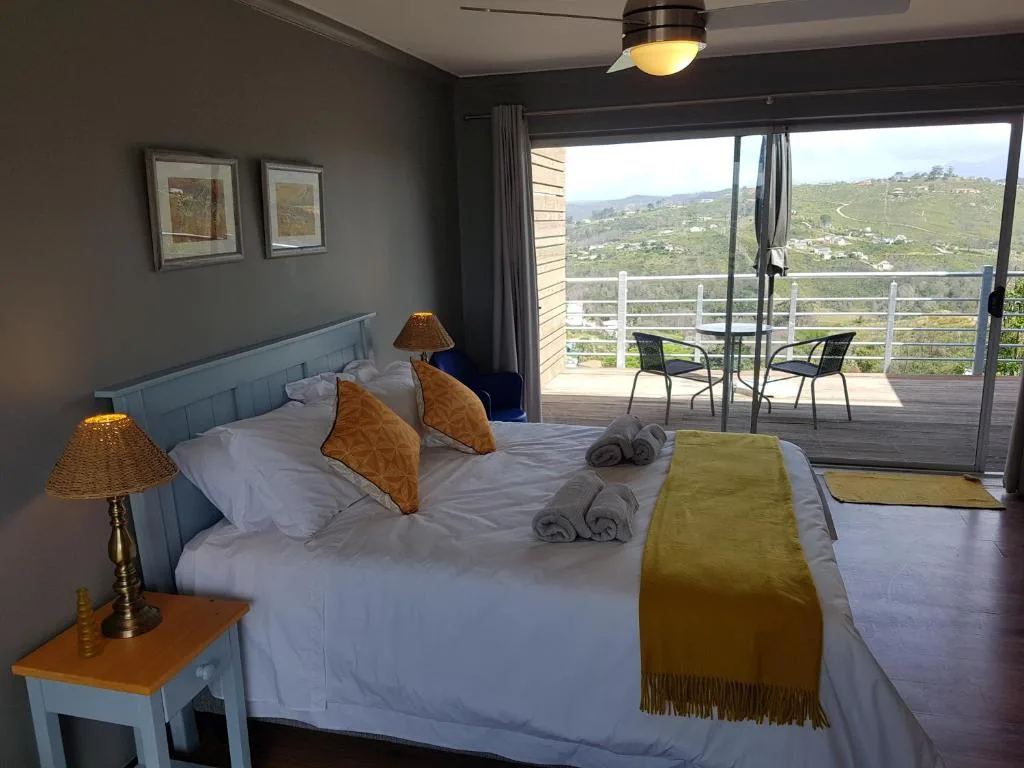 Spacious bedroom with panoramic mountain and valley views through glass doors