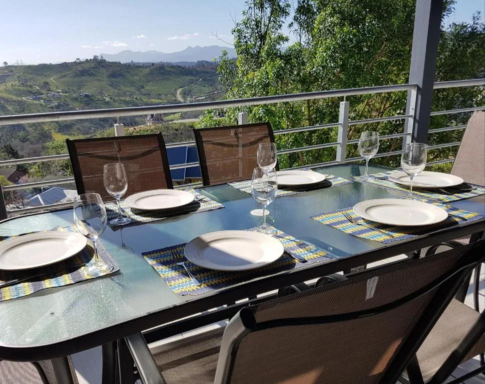 Outdoor dining table with place settings overlooking scenic mountain landscape