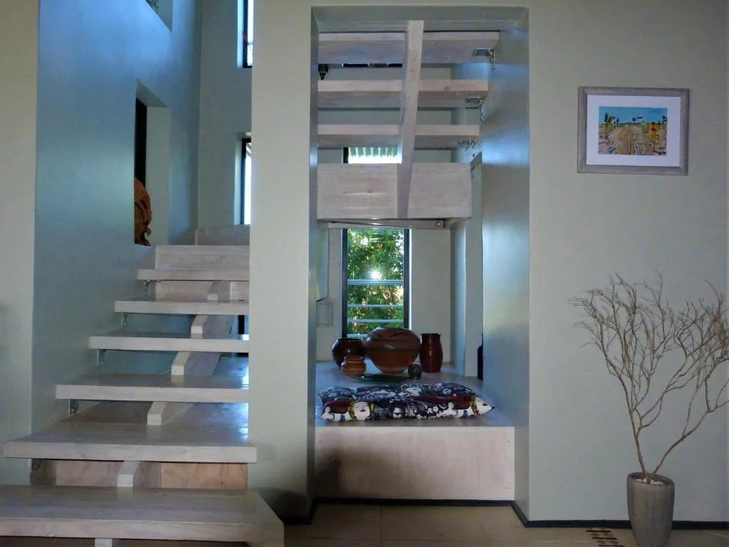 Modern interior staircase with wooden steps and glass railings leading downward