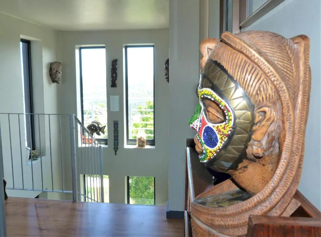Carved wooden African mask with colorful beaded details in interior space