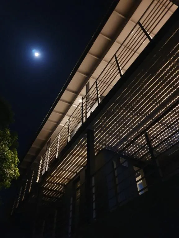 Modern exterior facade with horizontal slat screening, illuminated at night under moonlight