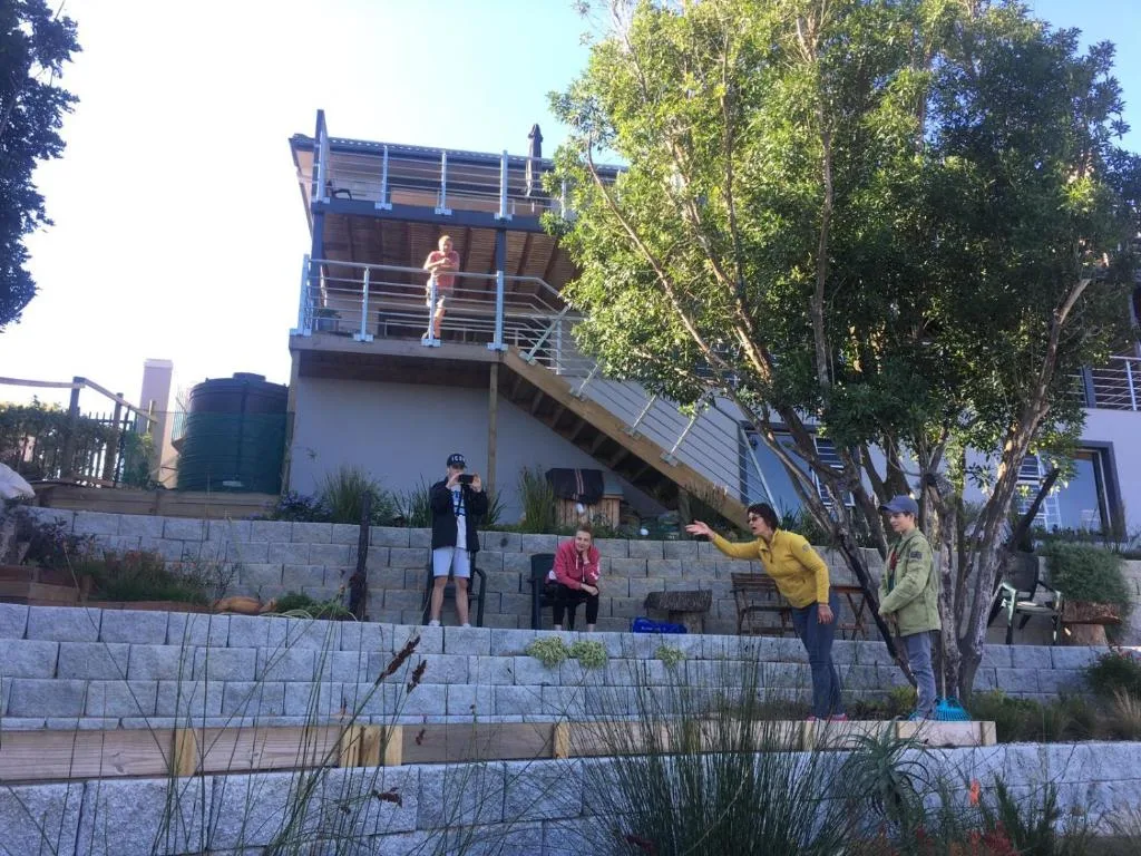 Modern two-story house with blue railings and terraced garden setting