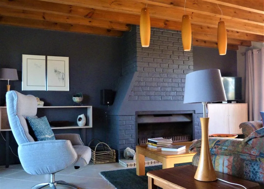 Modern lounge with fireplace, blue armchair, and wooden beams