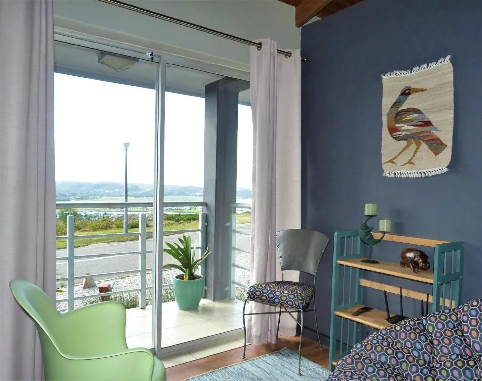 Modern lounge with green chair, sliding glass doors overlooking lagoon view