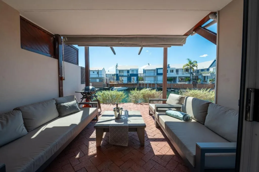 Covered patio with outdoor seating overlooking lagoon and neighborhood