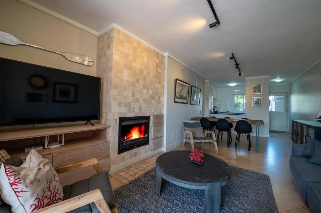 Modern lounge with fireplace, TV, and round coffee table with pink flower