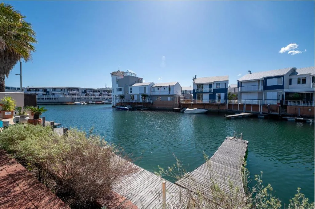 Turquoise lagoon with waterfront homes and wooden jetty, Knysna