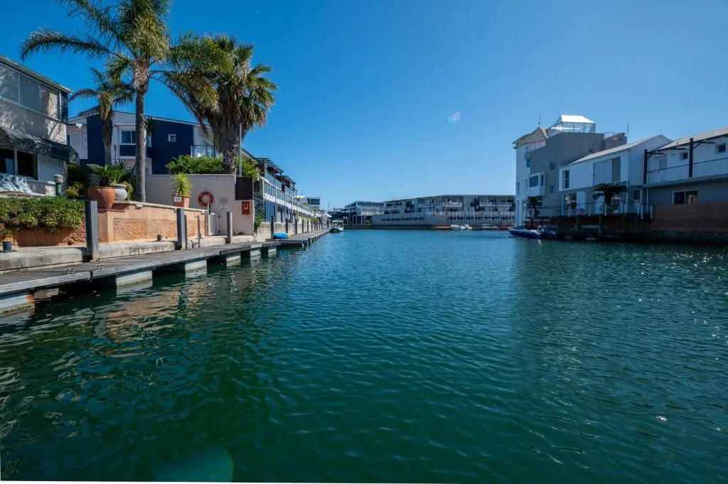 Waterfront lagoon view with colorful properties and palm trees lining the water