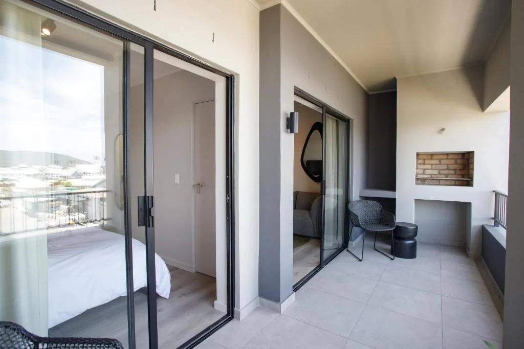Modern bedroom with ensuite bathroom and sliding glass doors to balcony