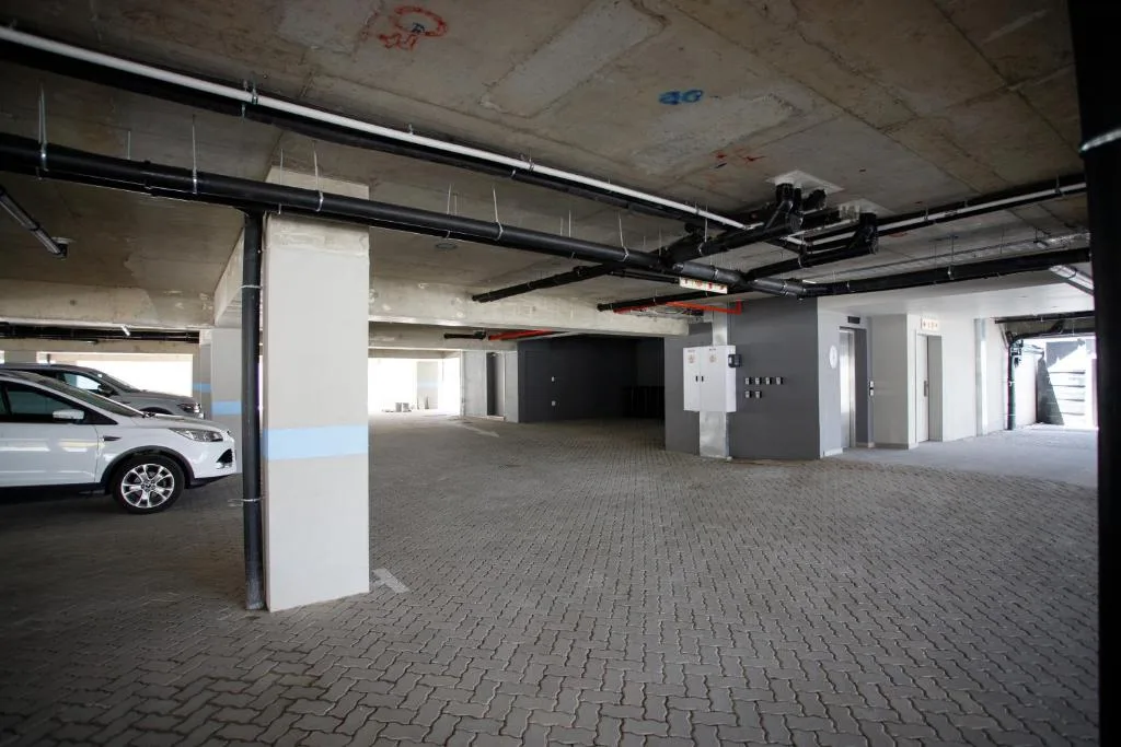 Spacious covered parking garage with paved floor and white support columns