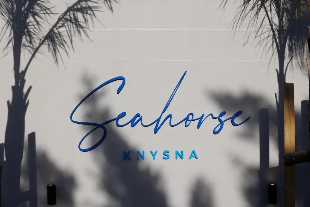 Seahorse Knysna entrance signage with palm tree shadows cast on glass